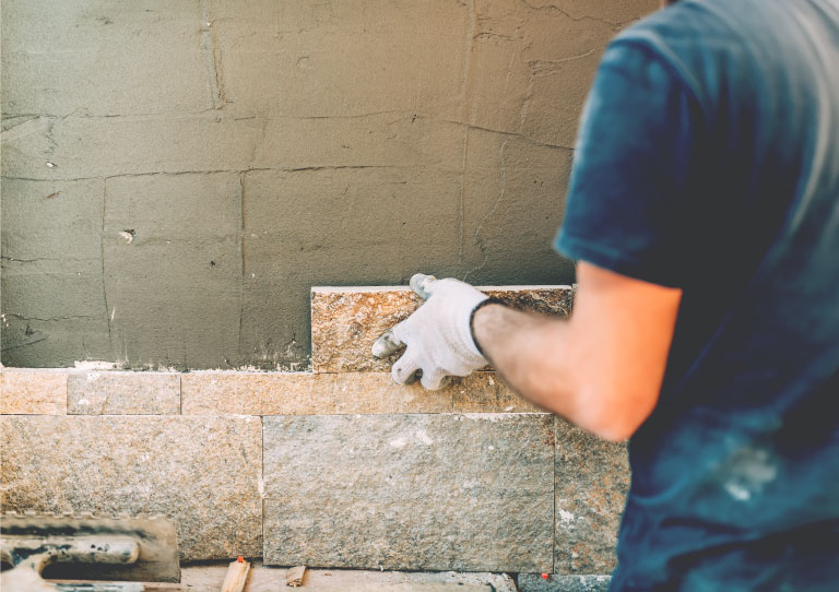 persona construyendo pared