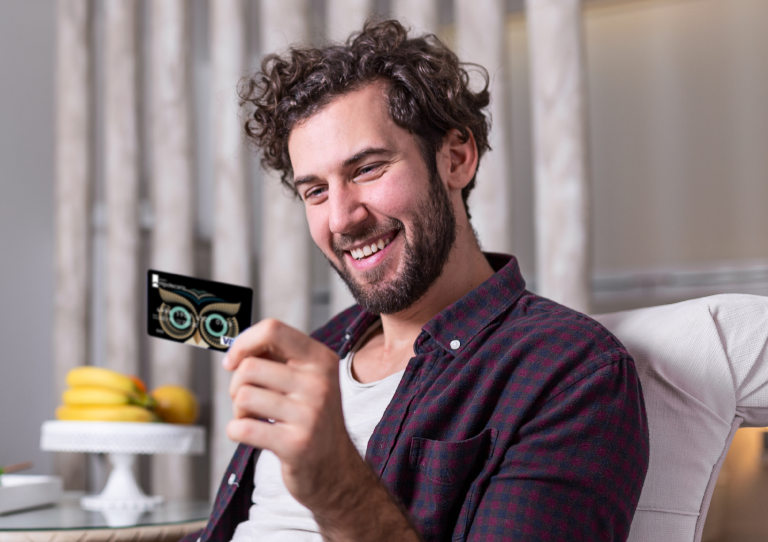 foto de un hombre con una tarjeta feliz por tener un pack búho inicia